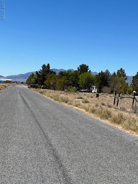 801 S Ford Loop, Pahrump, NV 89048 A paved access road leads toward the property against a backdrop of distant mountains.