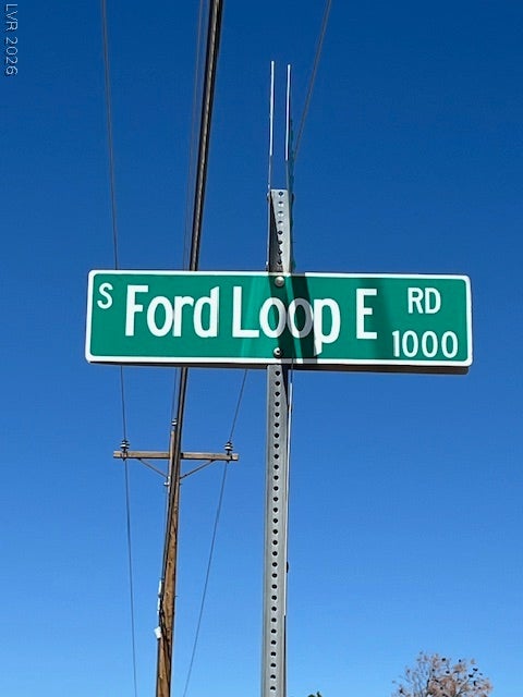 801 S Ford Loop, Pahrump, NV 89048 A green street sign marks the location of the property under a clear blue sky.