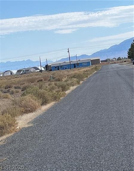 801 S Ford Loop, Pahrump, NV 89048 An asphalt road runs alongside a vast desert landscape with distant mountains.