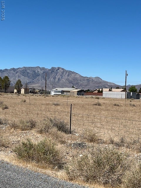 801 S Ford Loop, Pahrump, NV 89048 Expansive desert land parcels sit nestled beneath a dramatic mountain backdrop under clear blue skies.