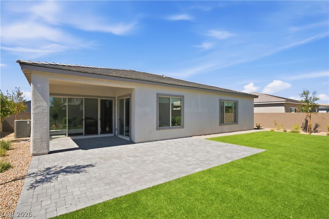 11164 Twisty Ridge Street, Las Vegas, NV 89183 A spacious paved patio adjoins a manicured green lawn under clear blue skies.