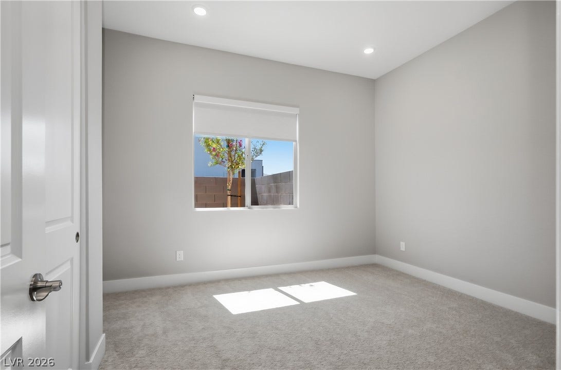 11164 Twisty Ridge Street, Las Vegas, NV 89183 A bright window and recessed lighting illuminate this carpeted room.