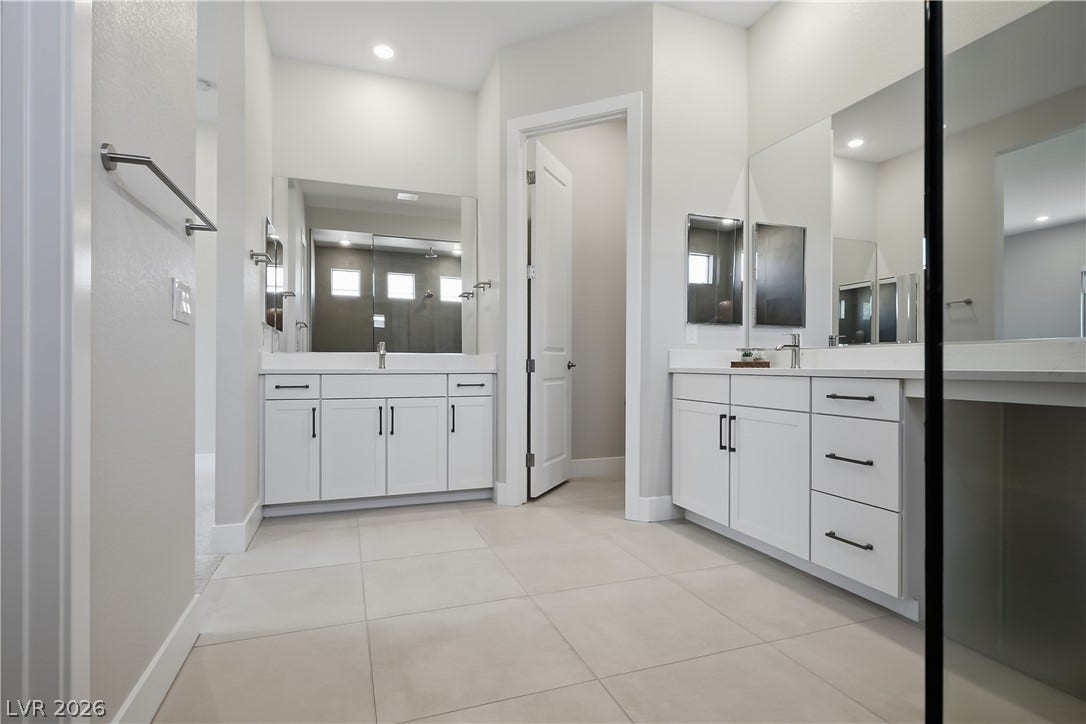 11164 Twisty Ridge Street, Las Vegas, NV 89183 Clean lines and dual vanities anchor this spacious master bath, featuring expansive tile flooring.