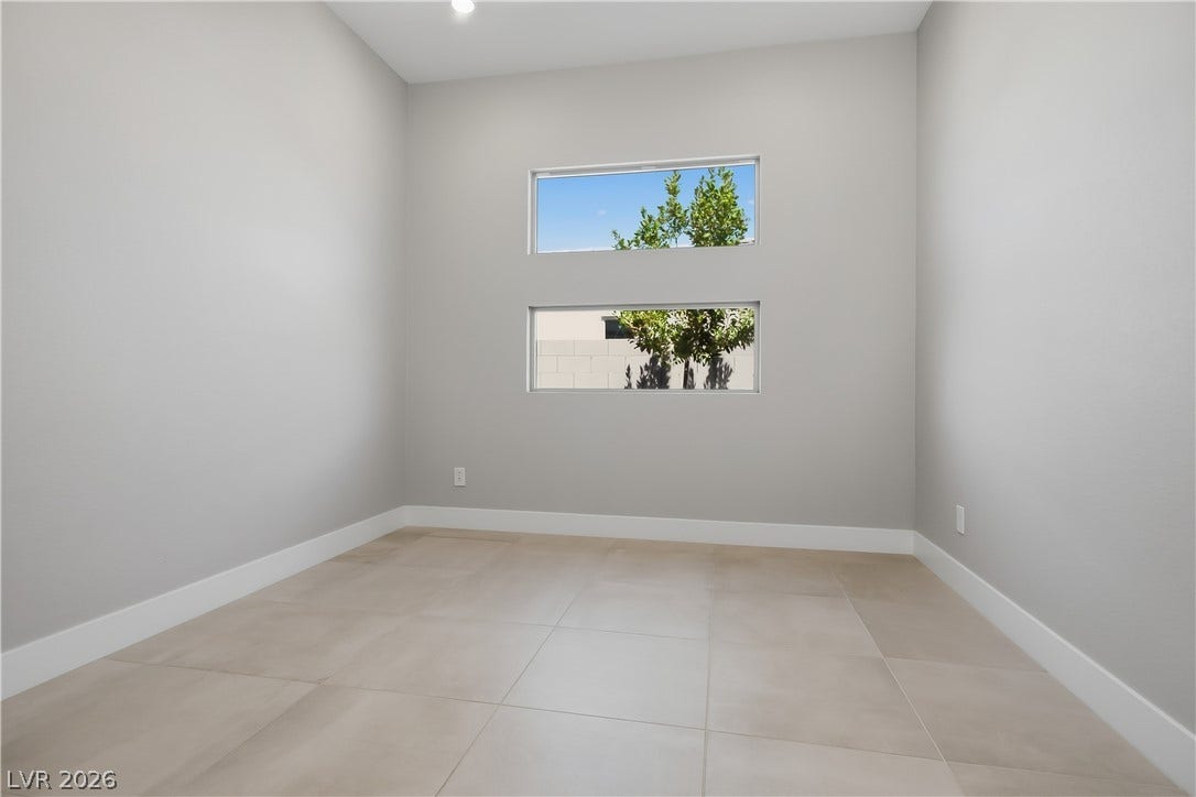11164 Twisty Ridge Street, Las Vegas, NV 89183 Stacked picture windows frame outdoor greenery above clean tile flooring in this versatile space.