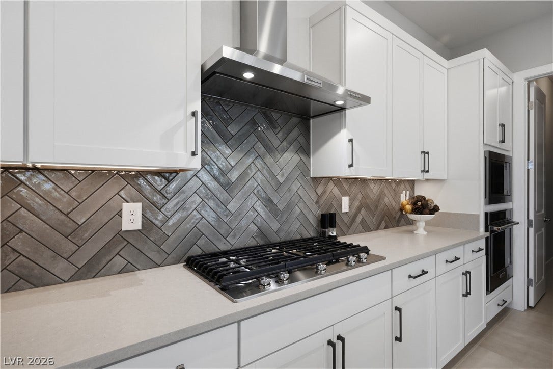 11164 Twisty Ridge Street, Las Vegas, NV 89183 Gleaming stone countertops and a modern range hood anchor this bright workspace.