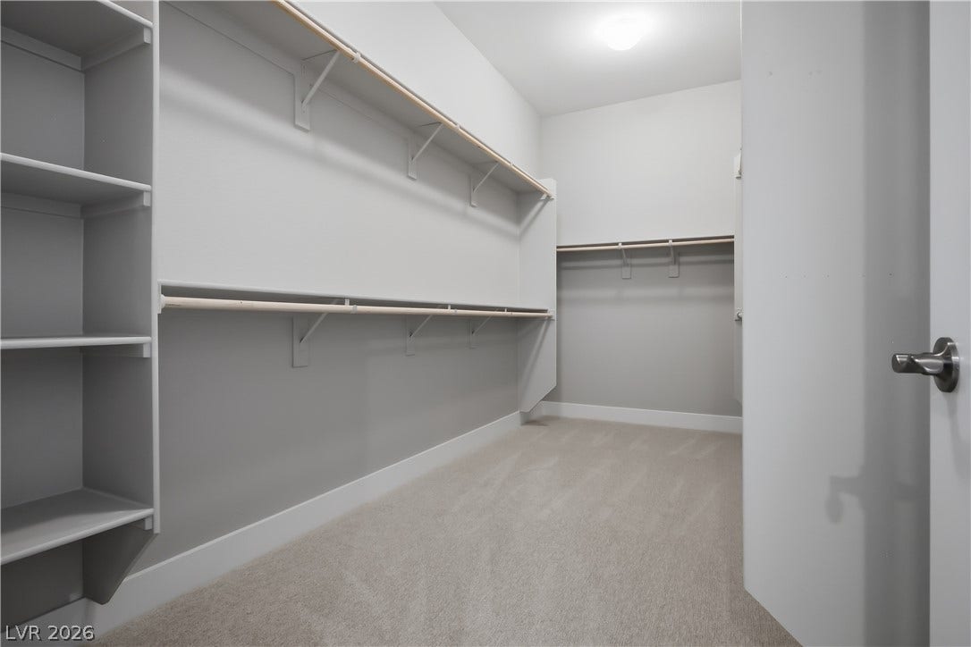 11164 Twisty Ridge Street, Las Vegas, NV 89183 Ample built-in shelving and hanging rods maximize storage in this carpeted walk-in closet.