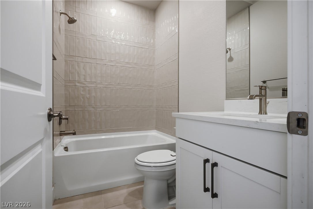 11164 Twisty Ridge Street, Las Vegas, NV 89183 Modern vertical tiling lines the shower and tub area in this updated bathroom.