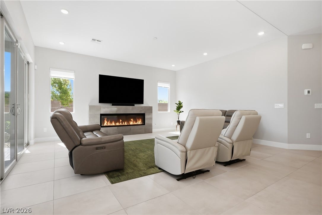 11164 Twisty Ridge Street, Las Vegas, NV 89183 Clean lines and a modern fireplace anchors this airy living space with tile flooring.