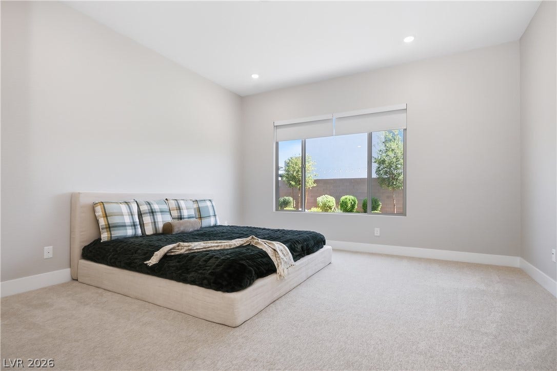 11164 Twisty Ridge Street, Las Vegas, NV 89183 Recessed lighting and plush carpeting define this serene bedroom space with views of the yard.