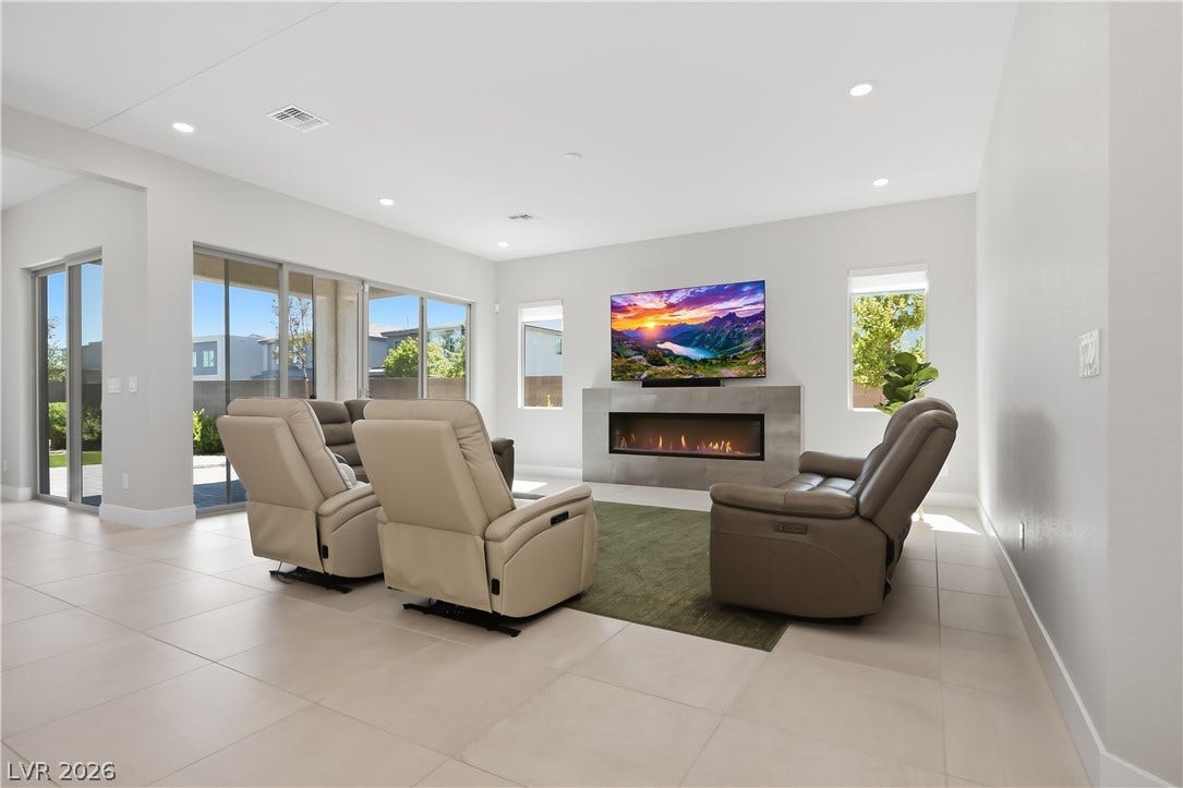 11164 Twisty Ridge Street, Las Vegas, NV 89183 Sliding glass doors and a modern fireplace elevate this light-filled living area.