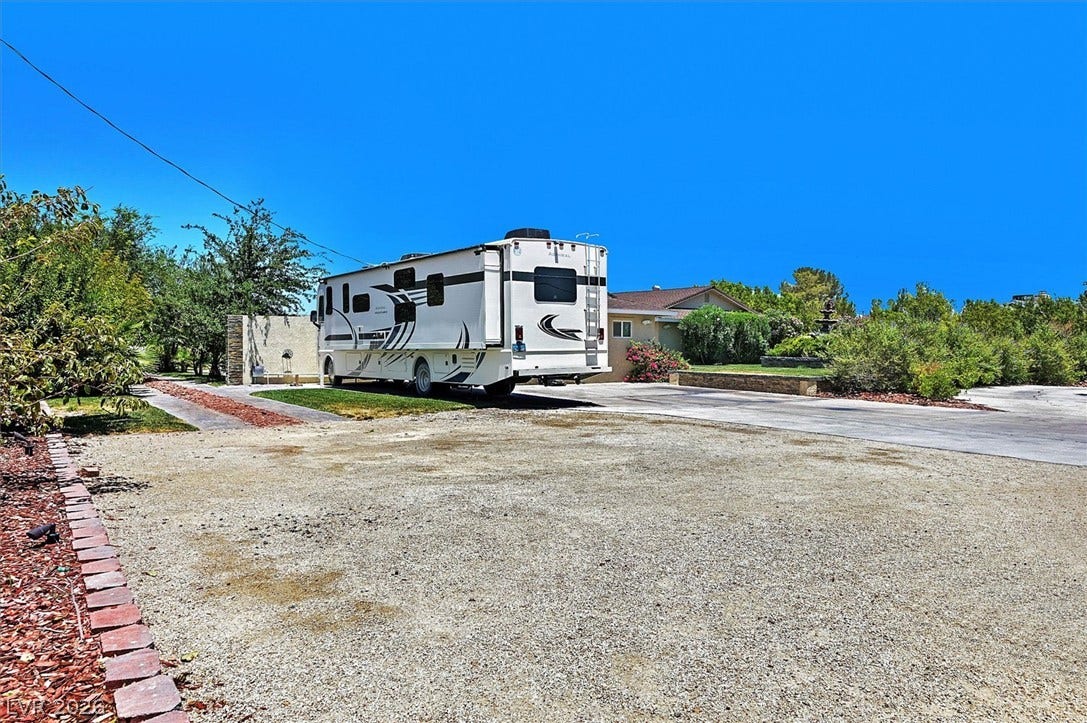 A spacious driveway and parking area offer ample space for vehicles and outdoor pursuits.
