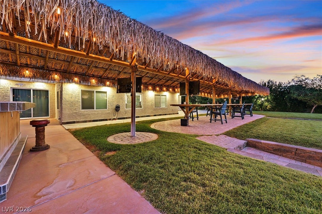 Entertain guests under a grand thatched patio, perfect for evening gatherings.