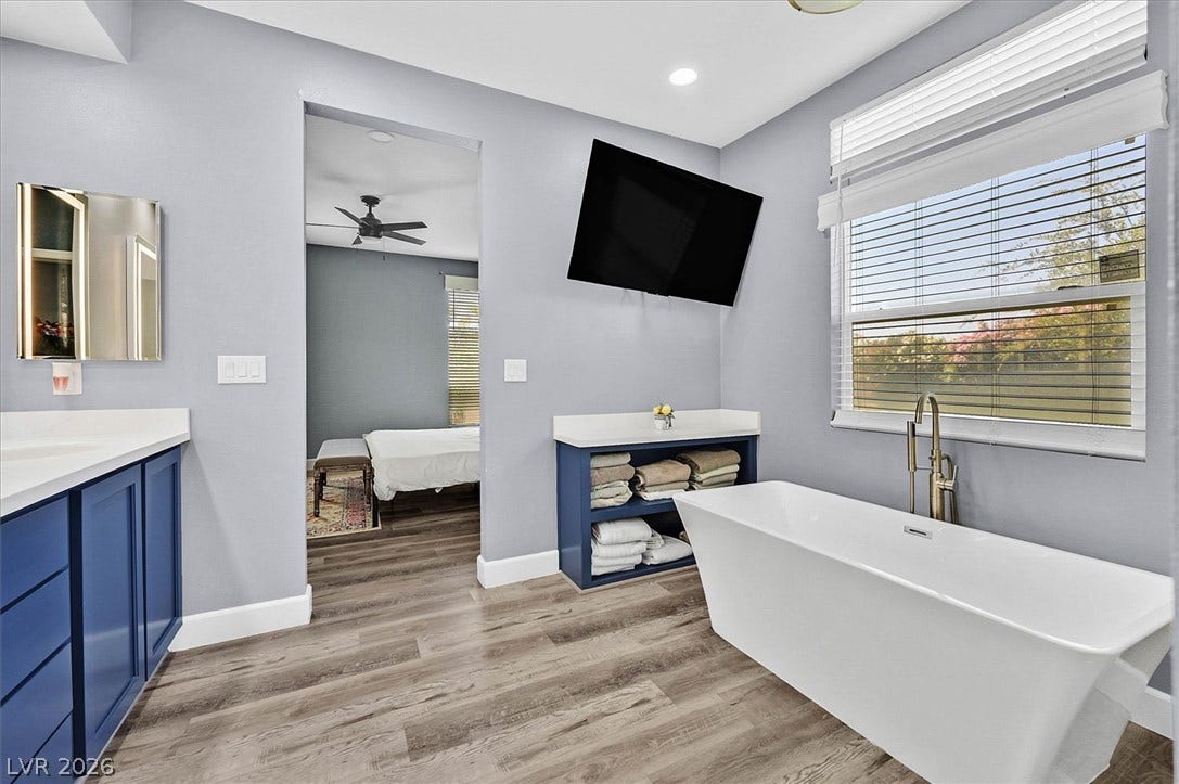 Indulge in relaxation within this primary bathroom, featuring a freestanding tub and ample vanity space.