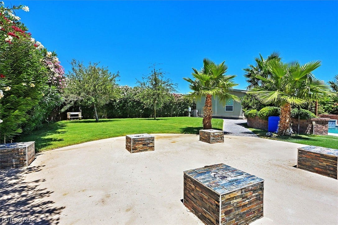 A sprawling green lawn and tropical foliage create a serene outdoor oasis.