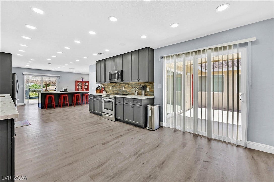 An open-concept kitchen with plentiful overhead lighting and direct patio access, ideal for seamless indoor-outdoor living.