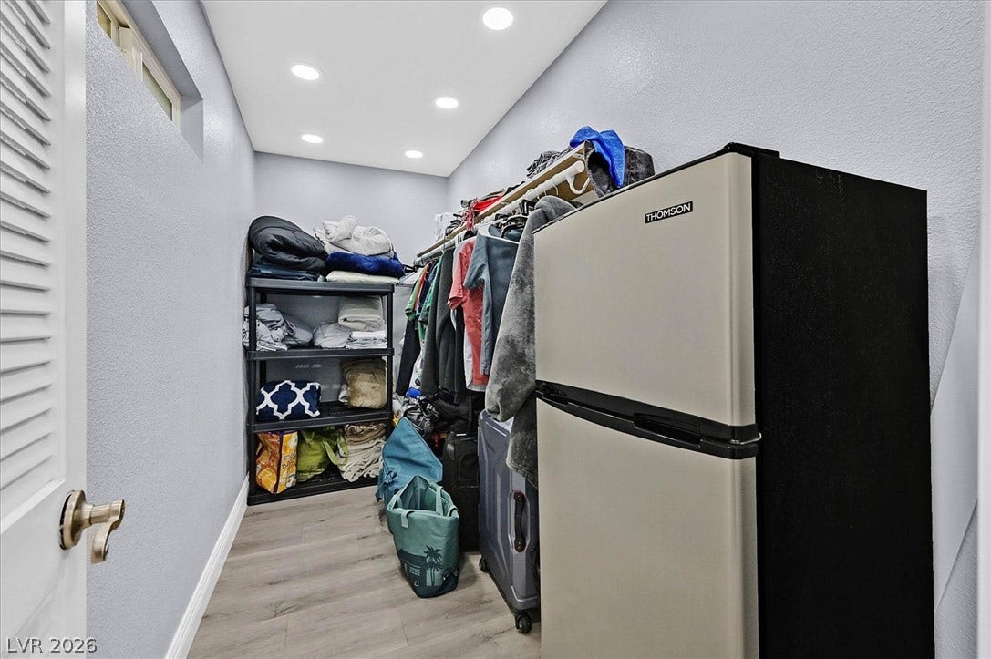 Functional walk-in closet with ample storage solutions, featuring practical shelving and recessed lighting.