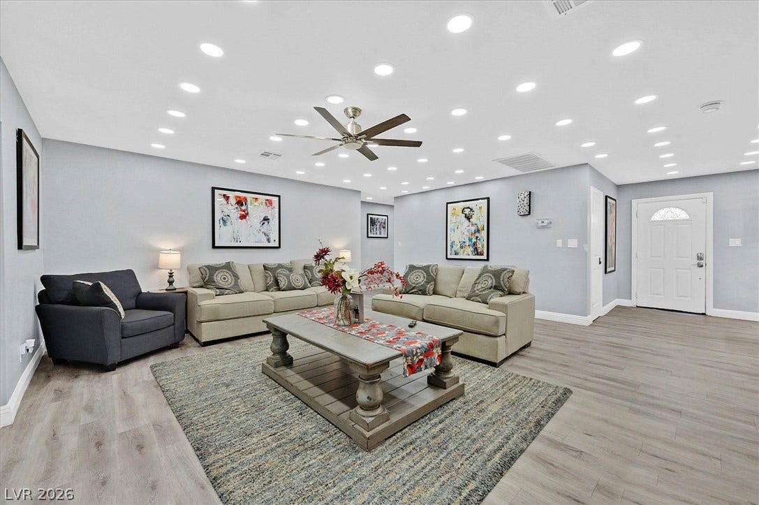 Recessed lighting illuminates this inviting gathering space with light wood-style flooring.