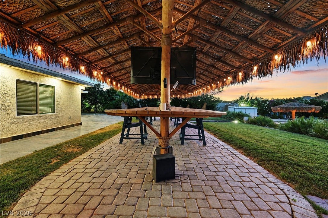 Entertain guests under this charming thatched patio, complete with built-in seating and illuminated string lights.