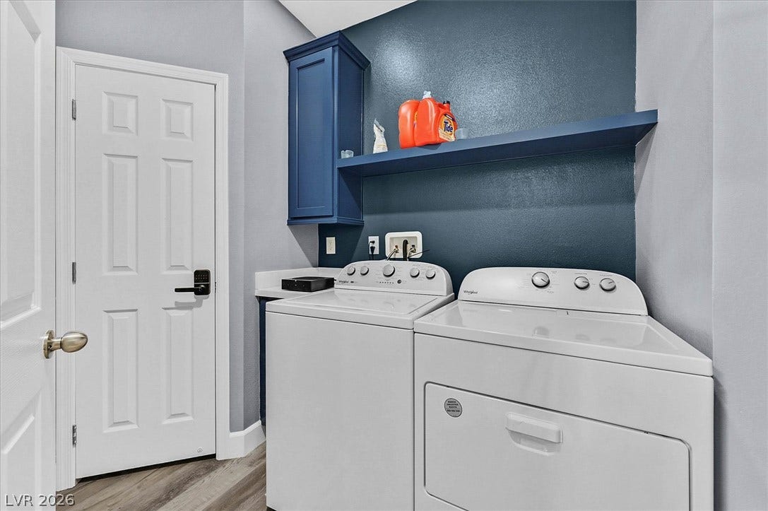 Functional laundry space featuring a washer, dryer, and convenient built-in shelving.