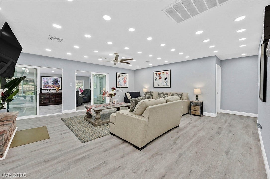 Recessed lighting illuminates this inviting living space with durable laminate flooring and direct patio access.