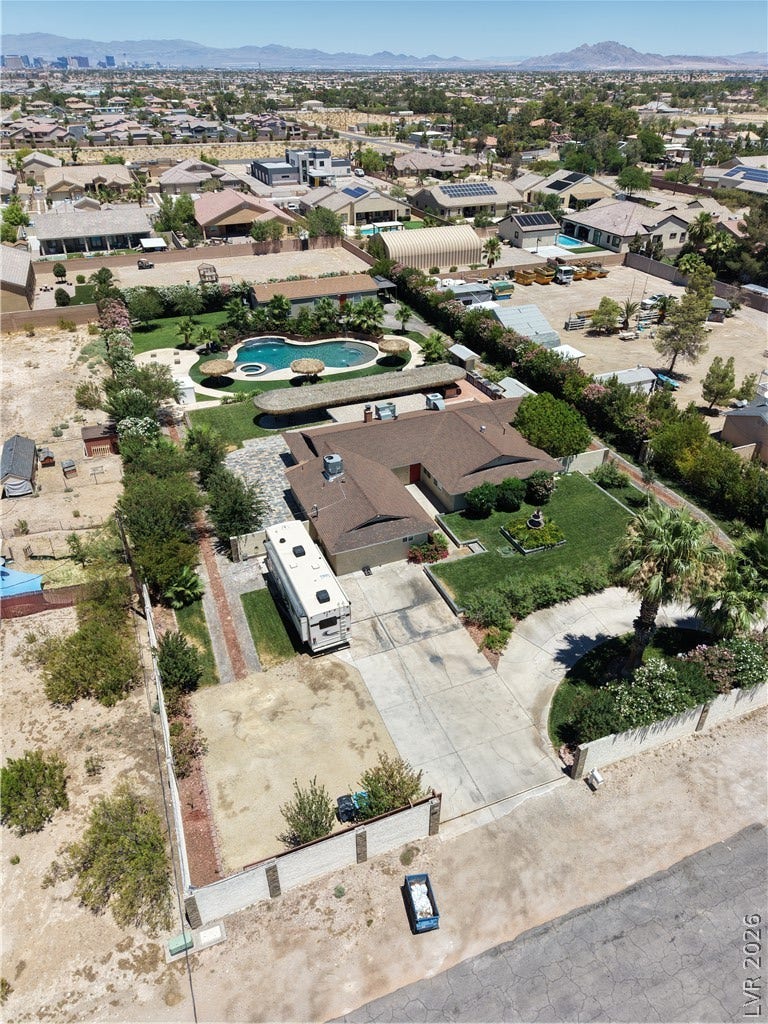 An aerial perspective reveals a spacious estate with a private pool and well-maintained grounds.