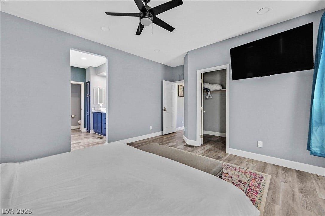 A well-appointed primary bedroom with recessed lighting and a ceiling fan, offering a private entrance to an en-suite bathroom.
