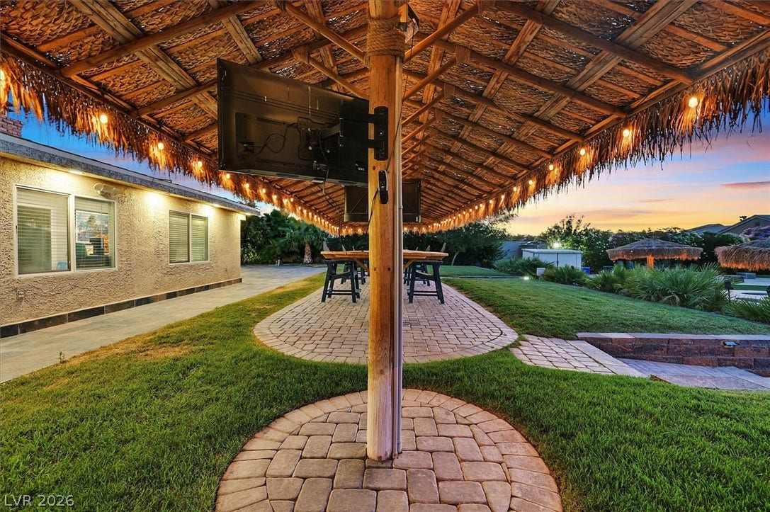 An inviting outdoor living area with a thatched roof patio, perfect for evening gatherings.