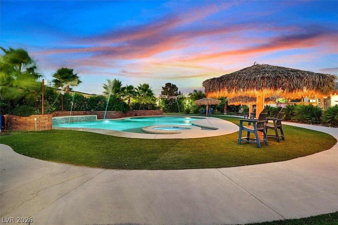 An inviting pool area with a spa, water features, and lush landscaping for ultimate relaxation.