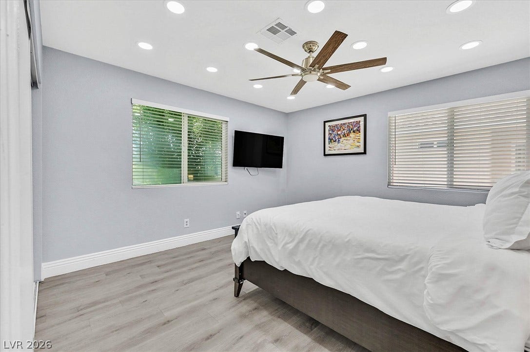 Relax in this tranquil sleeping space, featuring durable wood flooring and ample natural light.