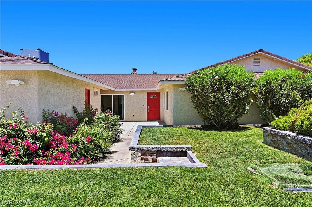 A vibrant landscape of manicured lawn and colorful floral accents creates inviting curb appeal.