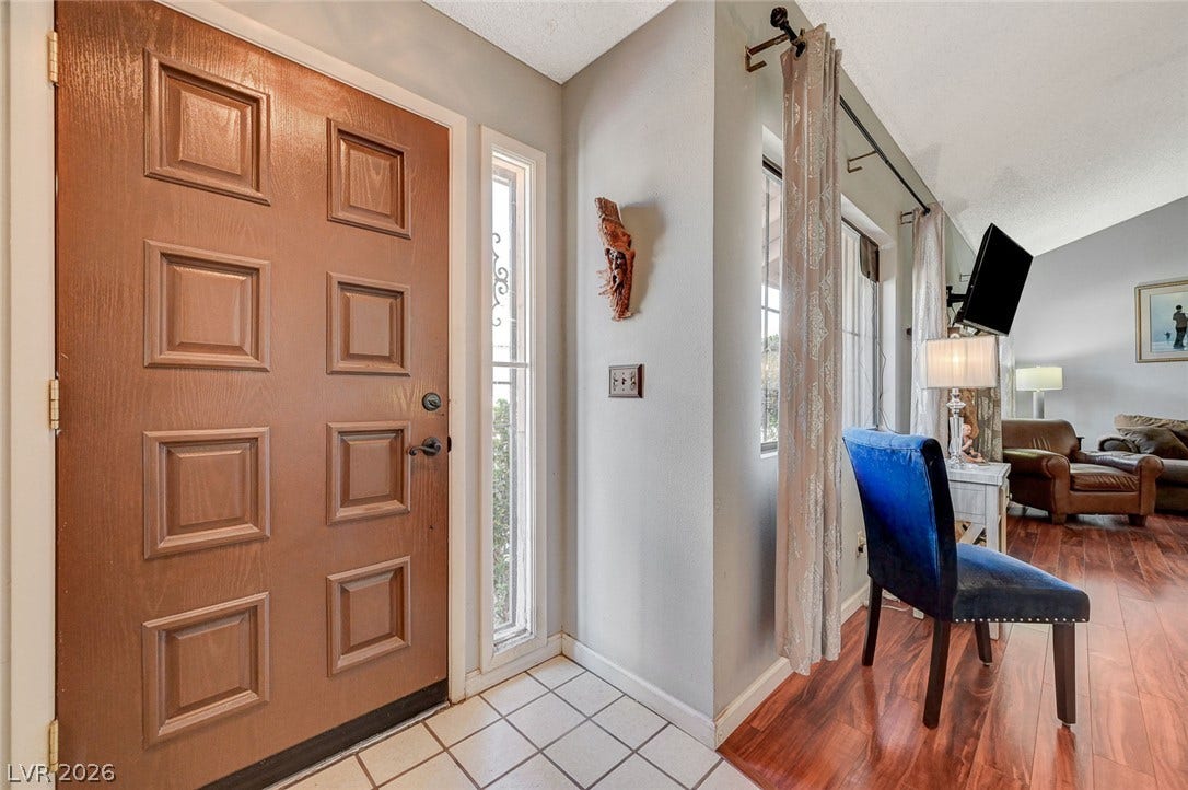 Rich wood flooring pairs with clean tile in this welcoming entry foyer.