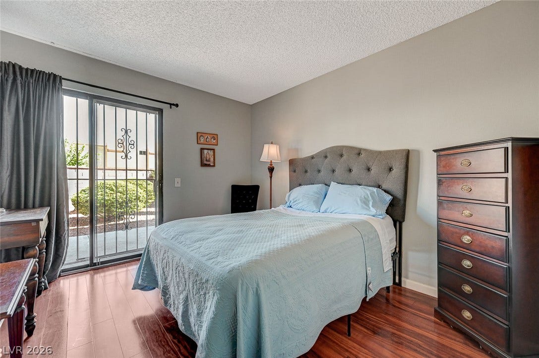 Gleaming hardwood floors and a sliding glass door elevate this quiet bedroom space.