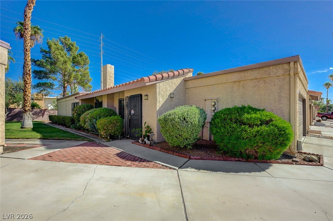 Spanish tile accents and manicured desert plantings frame the entryway of this single-level home.