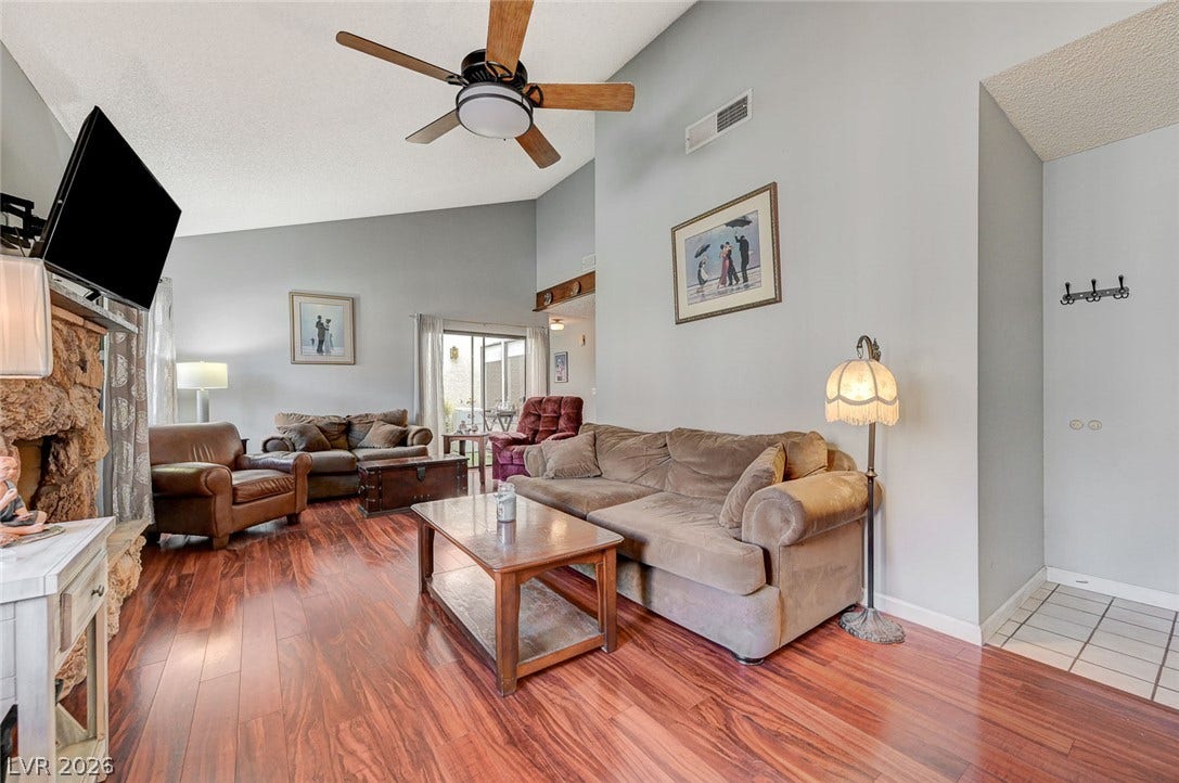 Warm wood flooring and vaulted ceilings define this inviting living area.