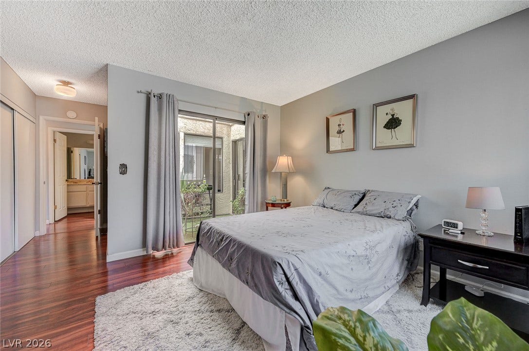 Rich hardwood floors complement the sliding glass door leading to a private outdoor space.
