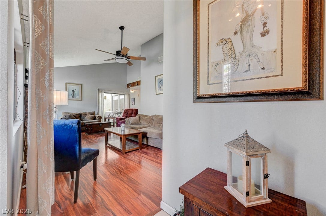 Warm wood flooring and vaulted ceilings create an open, welcoming atmosphere in this central living area.