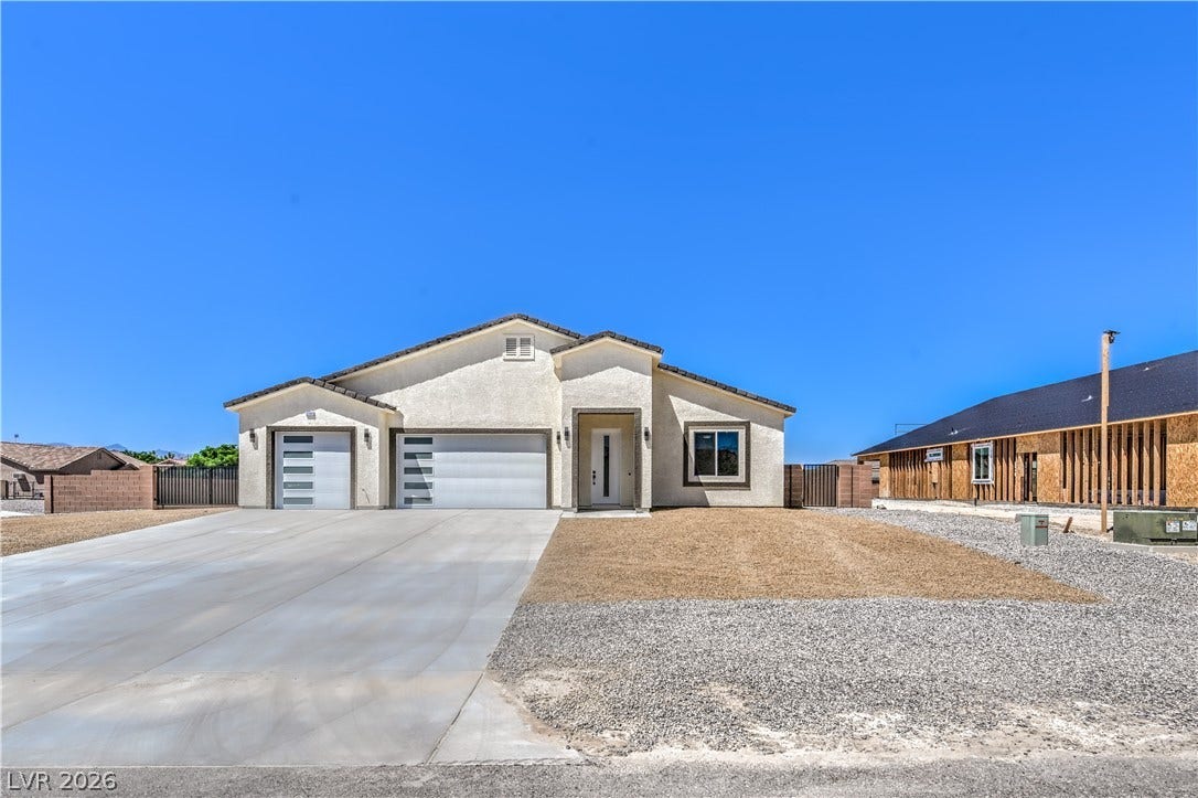 Single story home featuring an attached garage, concrete driveway, and stucco siding