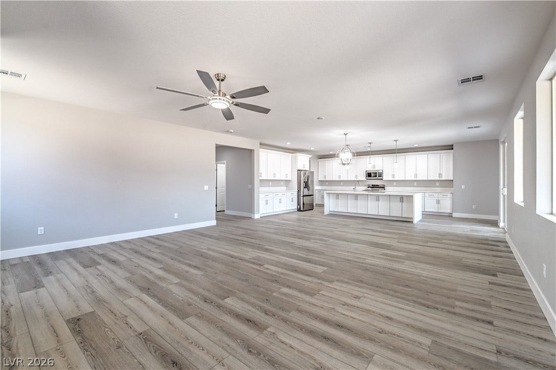 Unfurnished living room with light wood-style flooring and ceiling fan