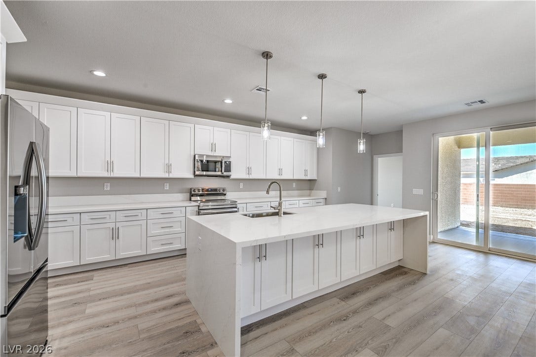 Kitchen with white cabinetry, stainless steel appliances, and recessed lighting