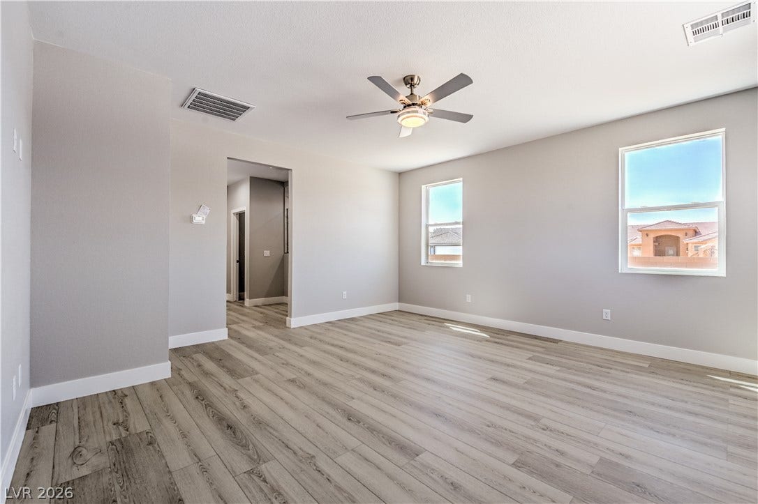 Empty room featuring light wood-type flooring and ceiling fan