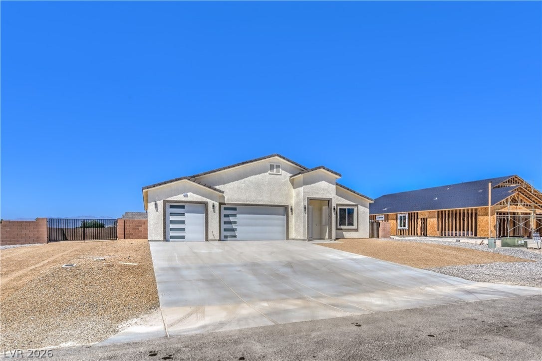 Modern home with an attached garage, concrete driveway, and stucco siding