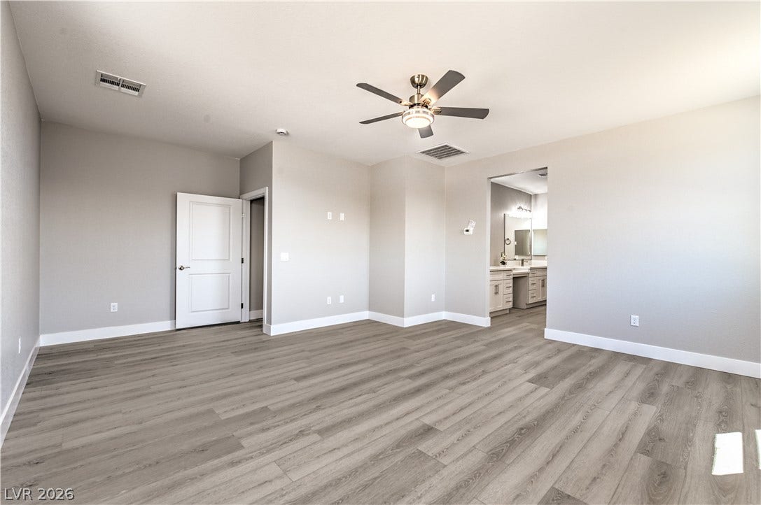 Empty room with light wood-style flooring and a ceiling fan
