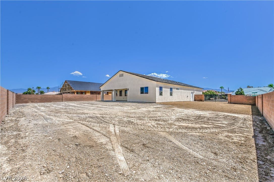 Rear view of property featuring a fenced backyard and stucco siding