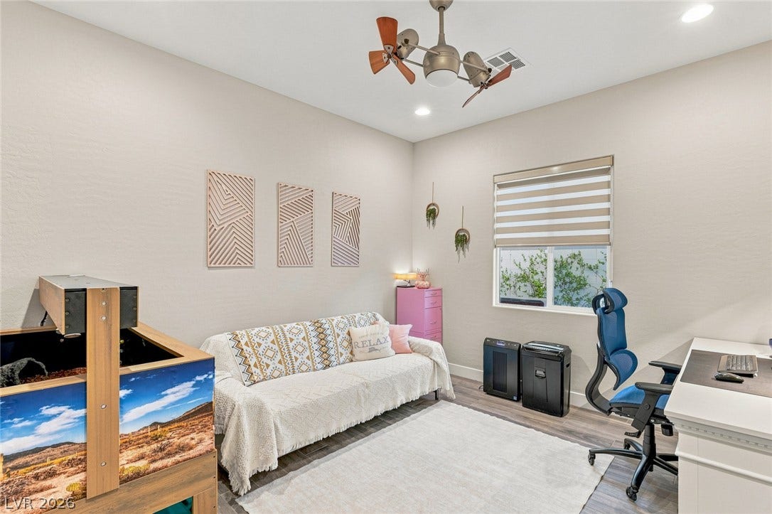 A versatile secondary room showcases smooth wood-look flooring and recessed overhead lighting.