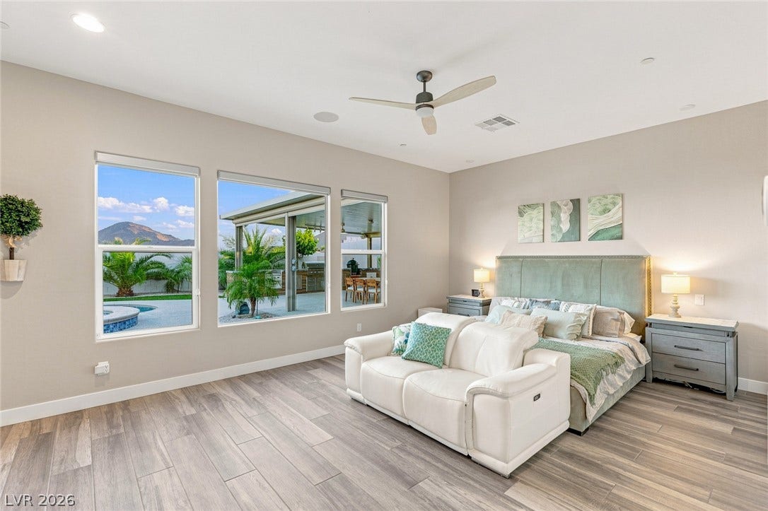 Large windows frame scenic mountain views in this relaxed bedroom featuring tile flooring.