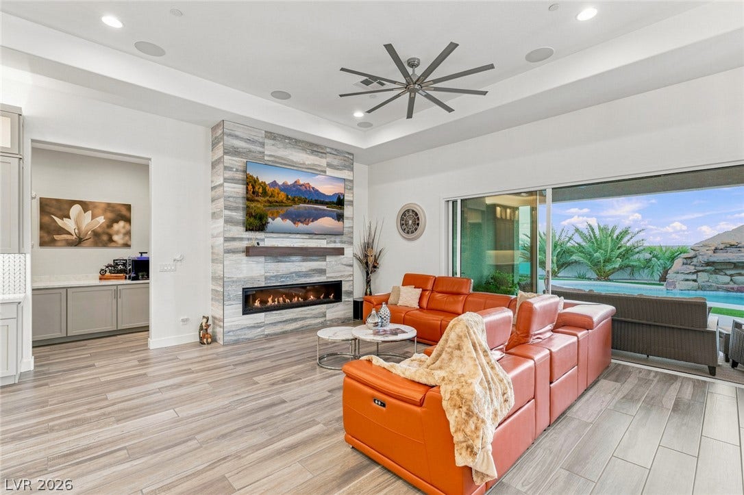 Recessed lighting, wood-look flooring, and sliding glass doors define this open living area.