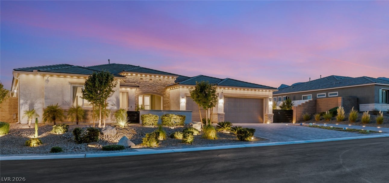 Artfully integrated stone masonry accents the front elevation of this elegant single-level residence.