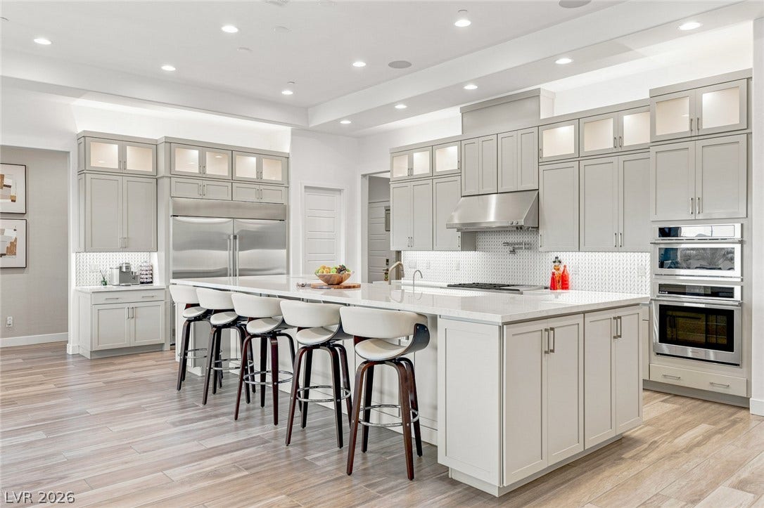An expansive kitchen features custom cabinetry, premium stainless appliances, and a massive central island.
