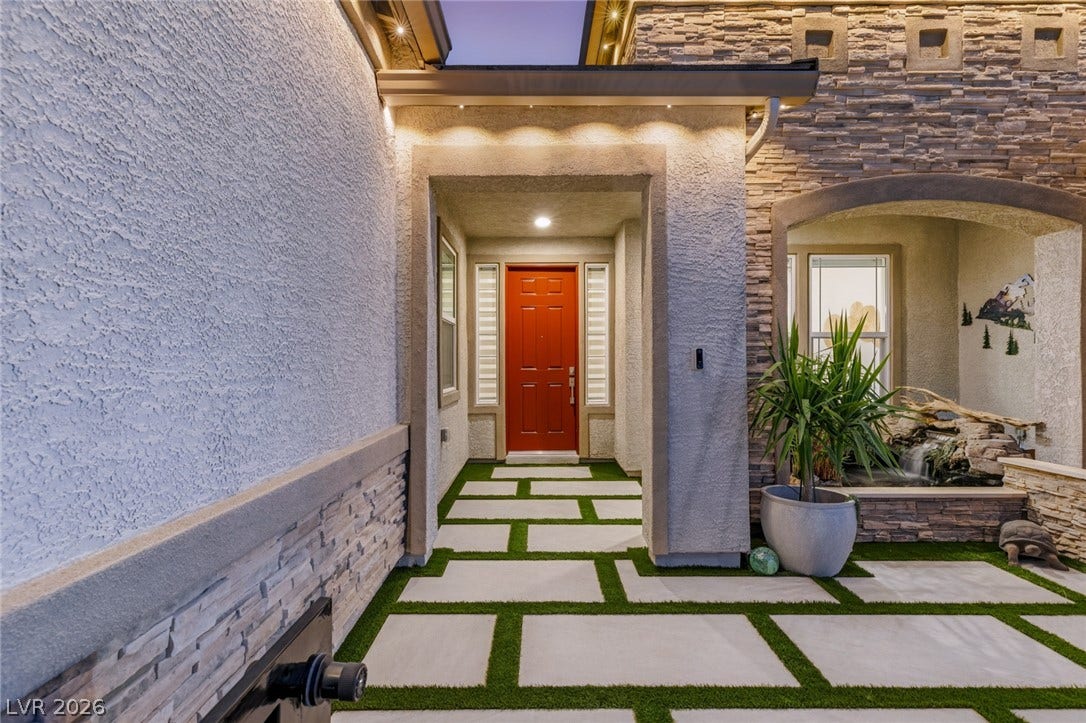 Elegant stone details and geometric pavers frame a welcoming entry pathway.