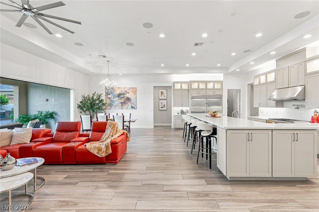An open floor plan integrates a grand kitchen with adjacent living and dining areas.